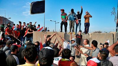 Protesters pull down concrete walls leading to the heavily guarded Green Zone. AP Photo