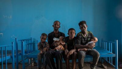 Tigrayan refugee Abraha Kinfe Gebremariam, 40, second left, sits for a photograph with his sons, Micheale, 5, left; Daniel, 11, center; his 19-year-old brother-in-law, Goytom Tsegay, second right, and his 4-month-old twin daughters Aden, right, and Turfu Gebremariam, on his lap, inside their family's shelter in Hamdayet, eastern Sudan, near the border with Ethiopia. AP Photo