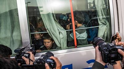 Children find themselves in the spotlight as they sit inside a bus during the handover of orphaned children of suspected ISIS fighters to a Russian delegation by Syrian Kurdish officials in Qamishli, north-east Syria. AFP