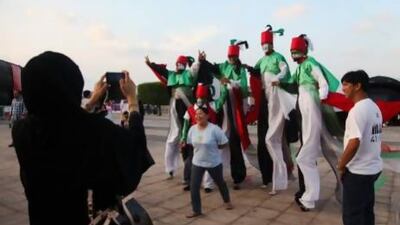National Day celebrations started today on Abu Dhabi's Corniche with jugglers and magicians. The events attracted locals and expatriates alike as the country looks ahead to its 42nd year. Visitors pose for a photograph with the UAE-themed stilt walkers. Lee Hoagland/The National
