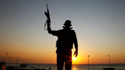 A Libyan rebel shoots in the air at a checkpoint in the Bab El Bahrah district in Tripoli, Tuesday, Aug. 23, 2011. Hundreds of Libyan rebels blasted through the green gates of Moammar Gadhafi's Bab al-Aziziya compound in Tripoli Tuesday after five hours o???