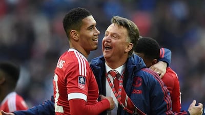 Louis van Gaal, right, congratulates Chris Smalling after Manchester United's 2-1 win over Everton in the FA Cup semi-final. Tony O'Brien / Reuters