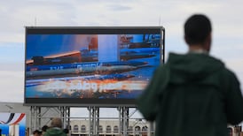A Houthi soldier stands guard in front of a digital billboard displaying missiles during a rally in solidarity with Iran in Sanaa, Yemen. EPA