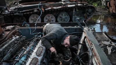 Volunteer soldier and former mechanic Gena Chiposhyn, 54, scavenges from an abandoned Russian tank near Izyum, Kharkiv region. AFP