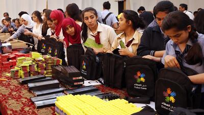 Schoolchildren and volunteers from Dubai participate in packing bags with stationery kits for Palestinian children. Satish Kumar / The National
