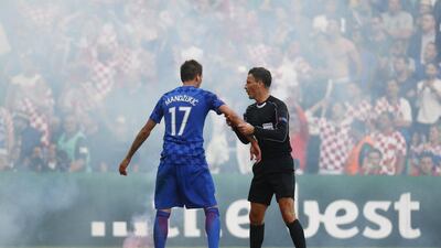 A flare is thrown onto the pitch by fans as Croatia’s Mario Mandzukic speaks with referee Mark Clattenburg during the Euro 2016 Group D match between Croatia and Czech Republic in Saint-Etienne. Kai Pfaffenbach / Reuters