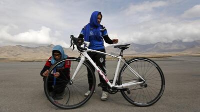 Masooma Alizada, left, and Frozan Rasooli, right, prepare a bicycle before training. Mohammad Ismail / Reuters