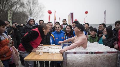 Cui Deyi, known as "Polar Bear," plays CHinese chess while being in a box filled with ice in Handan, Hebei province on January 16, 2016. Fred Dufour/AFP Photo
