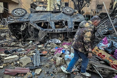 A man walks past the destruction at the site of overnight Israeli air strikes in the southern suburbs of Beirut on March 16, 2026. AFP