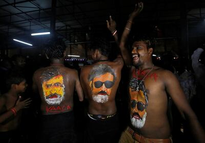 Fans with their bodies painted with images of actor Rajinikanth dance as they celebrate the release of his new movie 'Kaala' in Mumbai. Reuters