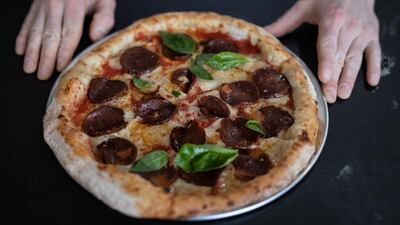 A Turkish pizza delivery man could be jailed for being caught on CCTV spitting on a customers pizza.