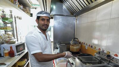 Abdul Rahim, owner of Desert Burger Cafeteria, frying French fries in his kitchen. Victor Besa / The National