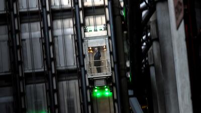 A man takes an elevator in the Lloyd's of London building in the financial district in London. Reuters
