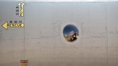 A Japan’s Maritime Self-Defense Force Personnel looks out through a window before taking off for Australia to join the search operation for the missing Malaysia Airlines flight MH370 at the Royal Malaysian Air Force base in Subang. Mohd Rasfan / AFP