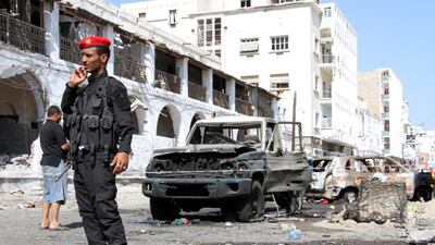 The remains of a suicide car bomb, which was shot by guards, next to the central bank in Aden yesterday. Saleh Al Obeidi / AFP