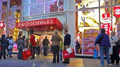 Shoppers stand outside the FAO Schwarz store in New York. Bebeto Matthews / AP Photo