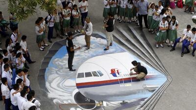 Filipino artists from the Guhit Visual Arts Group paint the image of Malaysia Airlines Flight MH370 at the Benigno Ninoy Aquino High School grounds in Makati City, south of Manila, Philippines, on March 17 to express hope and solidarity for the passengers and crew of the missing jet. Amiel Meneses / EPA
