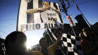 A Juventus supporter waves a flag showing player Carlos Tevez to celebrate their victory of the Serie A title on Sunday. Giorgio Perottino / Reuters / May 4, 2014