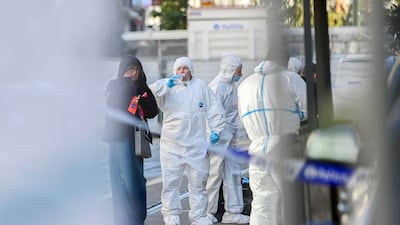 Forensics officers search for evidence in the street. AFP