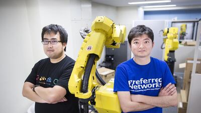 Toru Nishikawa, co-founder and chief executive of Preferred Networks (R) and Daisuke Okanohara, co-founder and vice president, with a Fanuc robotic arm at their company's headquarters in Tokyo, Japan. The four-year-old firm has become Japan’s most valuable start-up.Tomohiro Ohsumi/Bloomberg