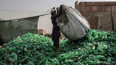 A labourer sorts plastic bottles for recycling at a warehouse in Kabul, Afghanistan. EPA