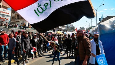 A woman waves an Iraqi flag during a protest in Tahrir Square, Baghdad, Iraq. AP Photo