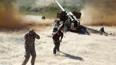 Members of the Popular Mobilisation Units, pro-government paramilitaries forces, cover their ears as they fire a multiple rocket launcher during clashes with Islamic State (IS) group jihdists in Iraq's northern Kirkuk. Mohammed Sawaf / AFP