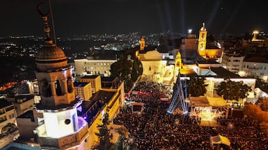 People gather in Nativity Square for a Christmas tree-lighting ceremony in Bethlehem, in the Israeli-occupied West Bank. AFP