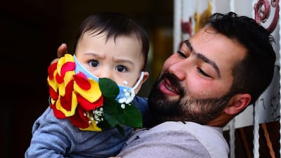 A child is seen wearing a mask embellished with petals in the central Iraqi holy city of Najaf amid the coronavirus pandemic. AFP