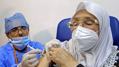 A woman receives a vaccine in Algeria as nations try to secure supplies for their domestic populations. AP