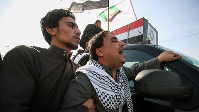 Members of the Saraya al-Salam (Peace Brigades), a group formed by Iraqi Shiite Muslim cleric Moqtada al-Sadr, grieve in a procession alongside a coffin during the funeral a fighter who was killed the day before in the northern city of Samarra during an attack by the Islamic State group (IS), in the southern city of Basra. Haidar Mohammed Ali / AFP