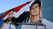 A street artist paints a mural of Iraqi midfielder Ibrahim Bayesh, right, alongside forward Aymen Hussein in Sadr City, east of Baghdad, on Monday. Iraq, whose preparations were disrupted by the war in the Middle East, have sealed their first appearance at the World Cup in 40 years. AFP