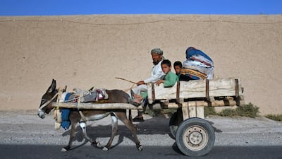 An Afghan man and his family ride through a village in the northern Balkh province. AFP