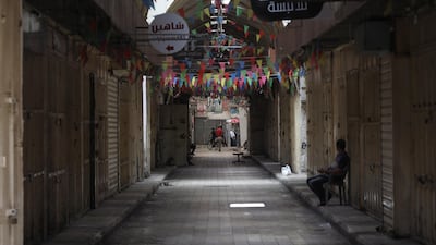 Palestinians walk in an empty street, in the West Bank city of Nablus. EPA