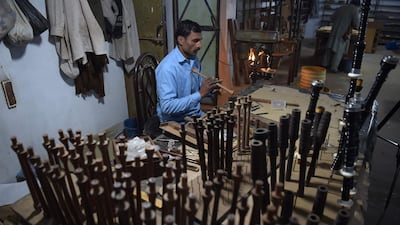 A Pakistani worker making bagpipes at the Mid East bagpipe factory. AFP.