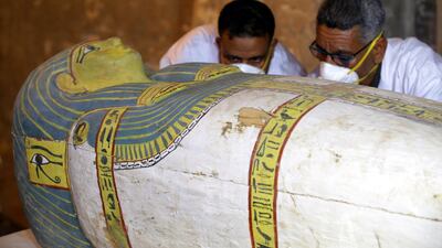 Egyptian archaeologists move the cover of an intact sarcophagus. EPA