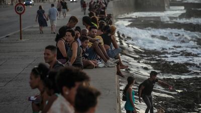 People pass the time at the seafront during a blackout after the failure of a power plant in Havana, Cuba. AP