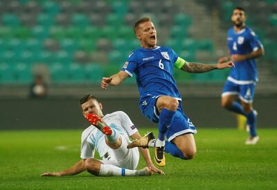 Jason Demetriou puts in a late tackle against Slovenia's Roman Bezjak and was later sent off for a challenge on Domen Crnigoj. Reuters