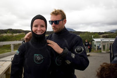 Diving instructor Lorenzo helps a tourist put on her hood before venturing into the icy waters. AFP