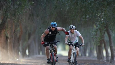Brett Bowie (left) and Berno vandenberg have a bit of fun as they ride along a path in Abu Dhabi that they are hoping to lay down tracks for mountain bike riders in Abu Dhabi. Delores Johnson / The National