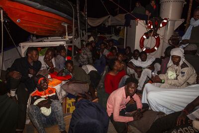 Rescued migrants sit in the search and rescue ship of German aid group Mission Lifeline as the boat remained stranded off Malta with 234 migrants aboard and no port at which to dock after both Italy and Malta refused to give authorization, early Monday, June 25, 2018 Mission Lifeline via AP