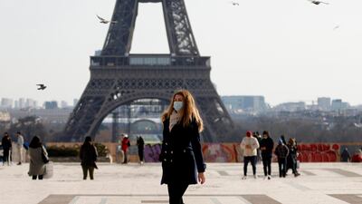 A woman walks past the Eiffel tower at the Trocadero in Paris. Output in France contracted 9.2 per cent last year. Reuters