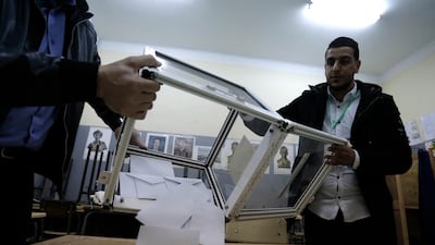 Polling station workers empty a ballot box in a polling station in Algiers. Algerians — without a leader since April — voted for a new president or boycotted and held street protests against the elections decried by a massive pro-democracy movement that forced former leader Abdelaziz Bouteflika to resign. AP