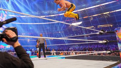 Logan Paul with a frog splash off the top ropes.