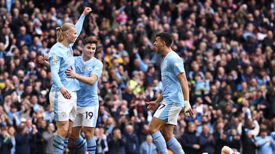 Manchester City's Erling Haaland celebrates the opening goal with teammates as Luton's Daiki Hashioka lies on the ground. AFP