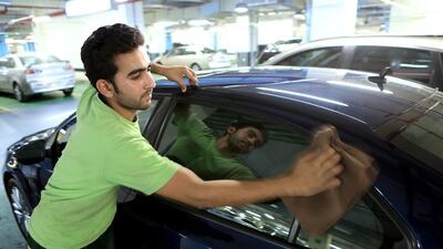 Muhammad Waqas Jamshaid thinks wearing gloves would help to protect his skin from the chemicals used to clean vehicles. Ravindranath K / The National
