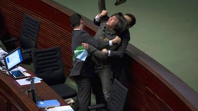 Pro-democracy lawmaker Leung Kwok-hung throws an object at Hong Kong's Financial Secretary John Tsang (not pictured) to demand a universal retirement protection scheme during the annual budget report at the Legislative Council in Hong Kong on February 25, 2015. Hong Kong announced measures totalling HK$290 million ($37 million) on Wednesday to help businesses hit by more than two months of pro-democracy protests as the government seeks to rebuild confidence in the Asia financial centre. Tyrone Siu / Reuters