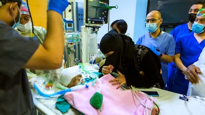 This handout picture provided by King Salman Humanitarian Aid and Relief Centre "KSRelief" on May 15, 2022 shows the Yemeni mother of conjoined twins checking on them following a their separation by Saudi specialist surgeons at a hospital in the capital Riyadh. - The "complicated" 15-hour operation successfully separated twin baby boys, Yussef and Yassin who were "conjoined in several organs", and some 24 doctors were involved in the operation to separate them, the official Saudi Press Agency (SPA) said. (Photo by King Salman Humanitarian Aid and Relief Centre / AFP) / == RESTRICTED TO EDITORIAL USE - MANDATORY CREDIT "AFP PHOTO / HO / KSRELIEF" - NO MARKETING NO ADVERTISING CAMPAIGNS - DISTRIBUTED AS A SERVICE TO CLIENTS ==