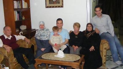 Magdy El Nashar, pictured holding one of his sons with his family in Cairo, says his name remains on an Egyptian blacklist and he has been banned from most travel.