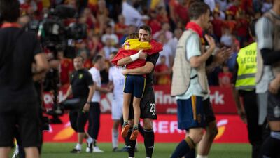 Spain goalkeeper Unai Simon hugs a young fan at the final whistle. AFP